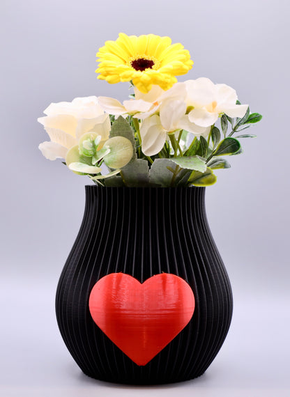 Schwarze 3D-gedruckte Designvase von Wälder Create mit rotem Herzmotiv, dekoriert mit Blumen – gefertigt im Bregenzerwald.